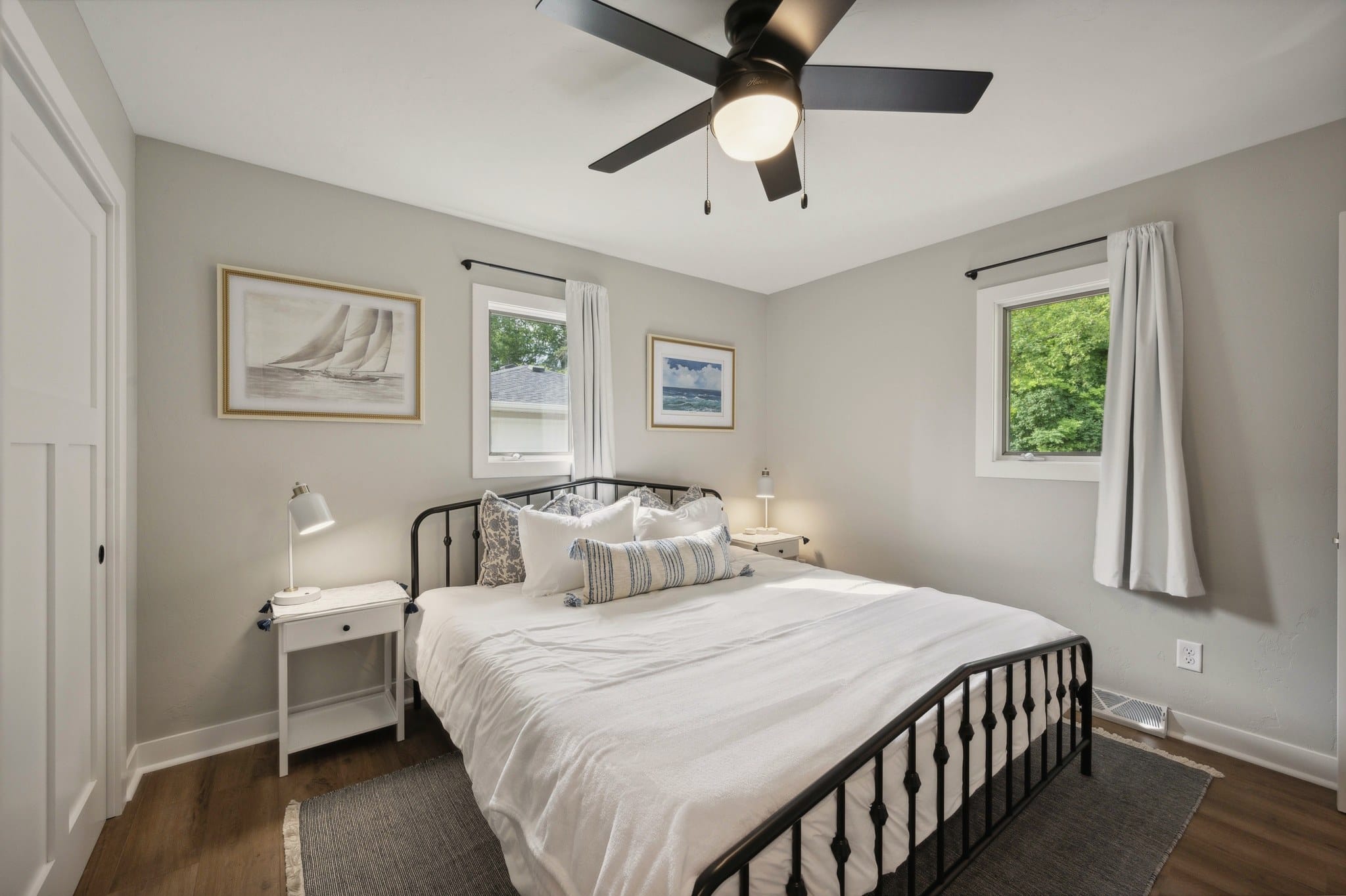Bedroom 1 at Serenity on Strauss with a black metal bed and ceiling fan.