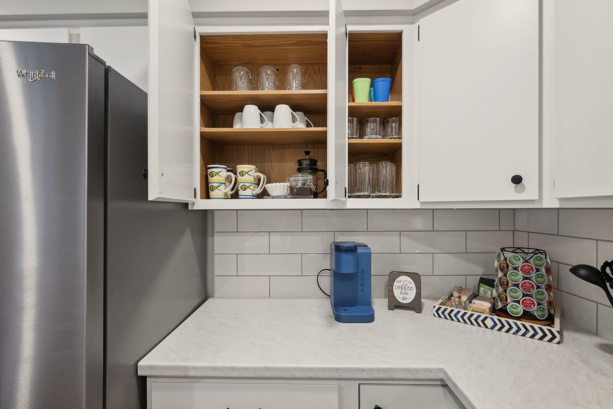 Coffee station and open cabinets with mugs and glasses, Serenity on Strauss.